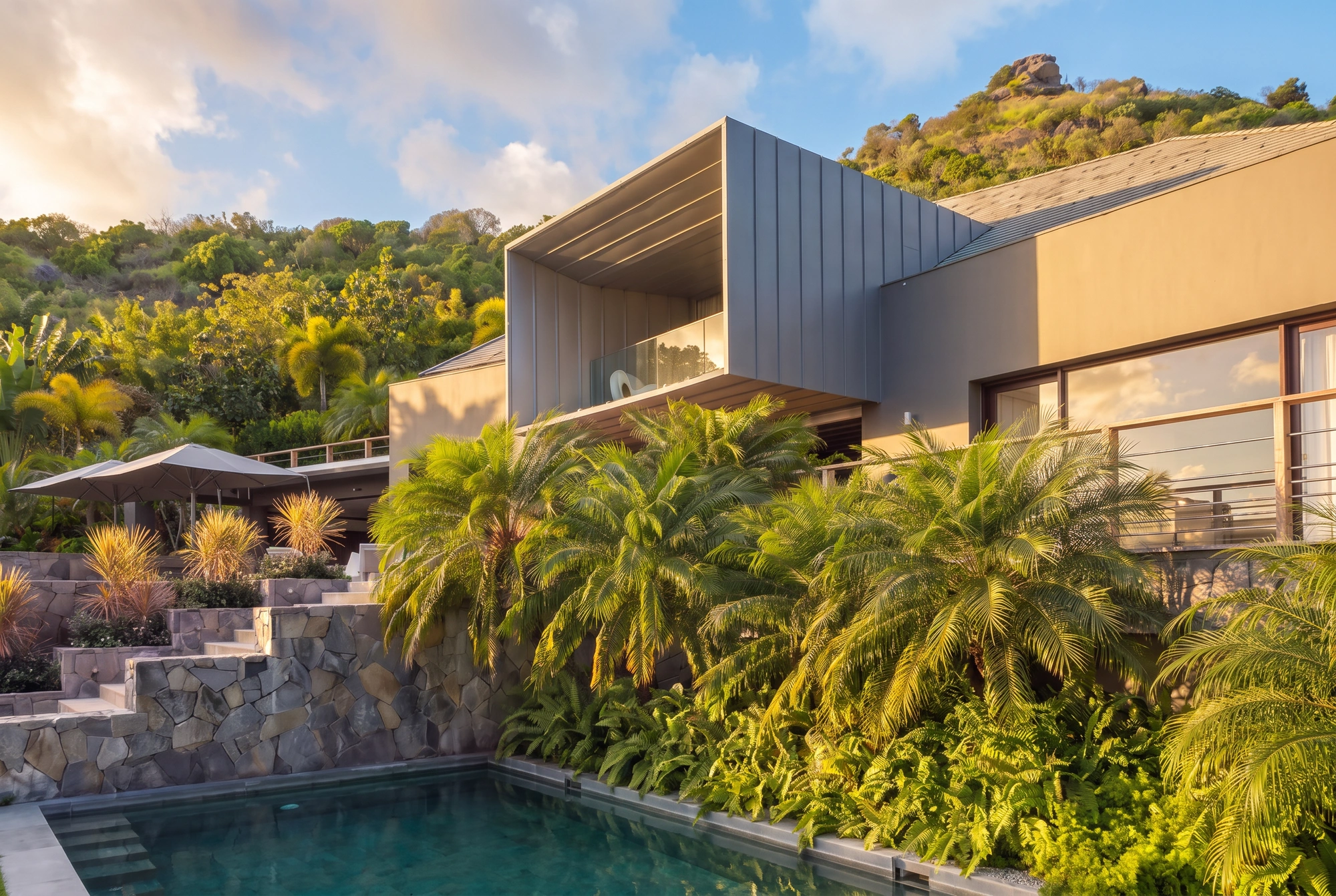 The house at the end of the day, above its pool and the terraced gardens