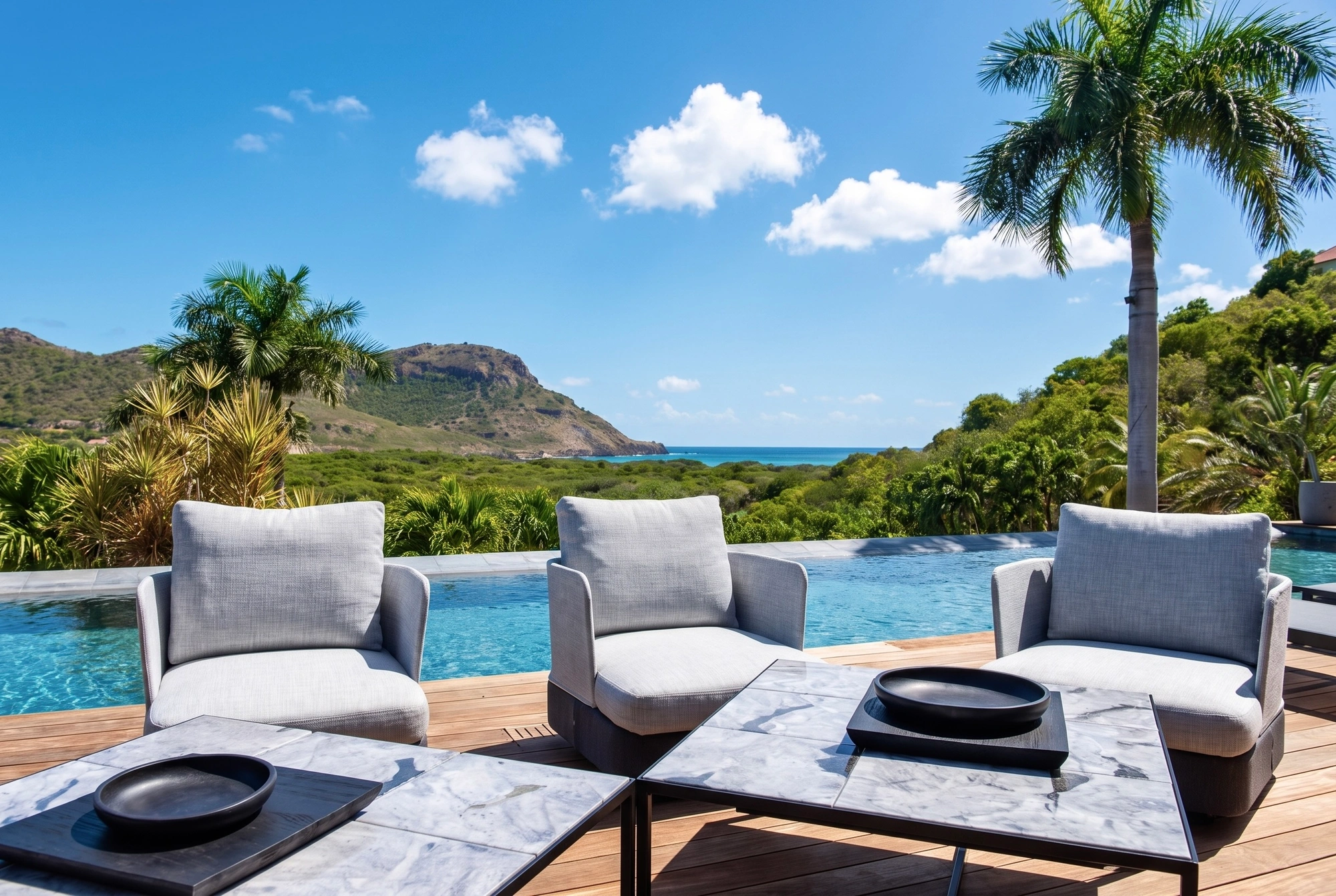 Armchairs by the pool, the sea beyond